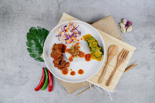 Buntil Beef Larva
A fusion dish combining savory spiced beef, rice, sambal, and a traditional leaf-wrapped coconut roll, beautifully plated for a modern take on a heritage recipe.