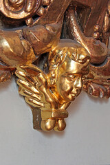 Detalle decorativo escultórico de ángel en dorado