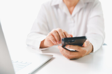 Close-up businesswoman using smart mobile phone at office table, female student is home studying online e-learning, searching for information on internet, engaging with social networks.