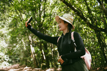 Young female traveler with backpack walking in national park or forest. recreation sport in nature. Female person bag, wave for hiking journey in woods. adventure in forest. trekking with backpack