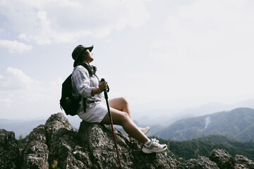 Woman hiker on top of mountain. Hiker with arms up on top of mountain successful young woman enjoying triumph. traveler exploring world. Hikers with backpacks relaxing. Sport and success concept.