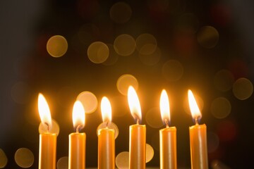 Obraz premium Close-up of lit candles in a row burning