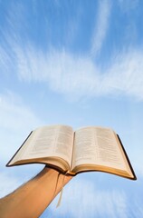 Low angle view of hand holding open Bible