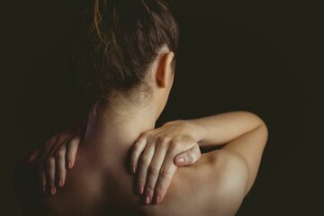 Woman silhouette is standing with hands resting on shoulders in flat design on dark background