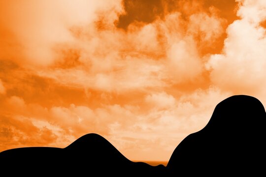 Fototapeta Silhouetted rolling hills are creating minimalist flat design scene with warm orange sky and clouds