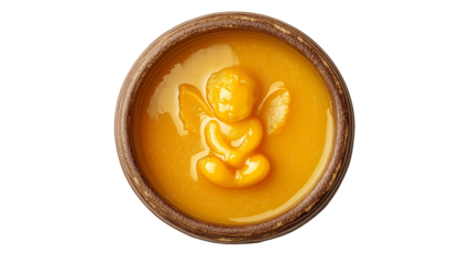 Angel Carving in Yellow Wax Inside Ceramic Bowl .Top view of a rustic ceramic bowl filled with smooth yellow wax or honey featuring a detailed angel or cherub carving in the center