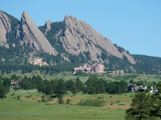 The Flatirons and NCAR surrounded by green hills in early summer, Boulder, Colorado