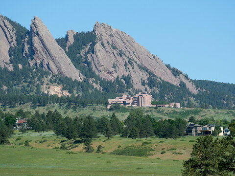 The Flatirons and NCAR surrounded by green hills in early summer, Boulder, Colorado