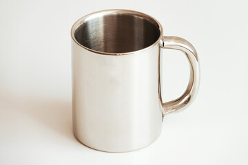 Clean and simple image of a silver-toned stainless steel mug with a comfortable handle, set against...
