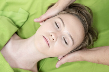 Top view of woman getting facial massage. 