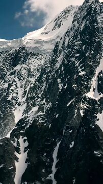 FPV bird's eye view drone flight over snow-covered mountain peak stunning winter landscape aerial shot