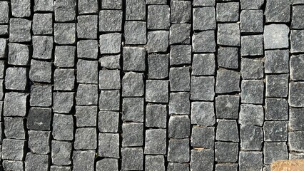 Gray abstract pattern background of cobblestone pavement top view.