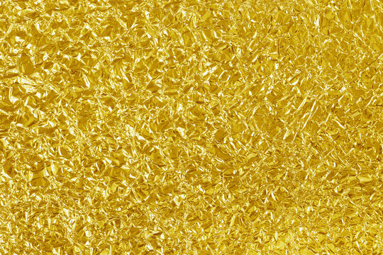 Gold foil leaf shiny texture, abstract yellow wrapping paper for background and design art work.