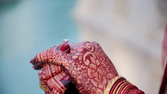 ENGAGEMENT ring on Traditional henna painting on bridal hands. Red color is the traditional Indian clothes, Elements of hindu wedding. 