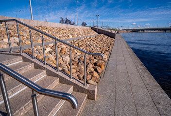 An embankment with a staircase with a shore reinforced with stones.