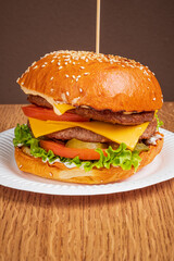 Delicious burger stacked high with lettuce, tomato, cheese, and savory beef patty, ready to enjoy