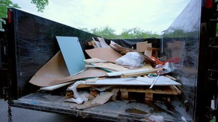 View of Dumpster full of garbage from construction site. Loaded truck view from inside