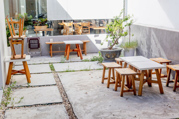 Cozy outdoor cafe patio with wooden furniture and potted plant