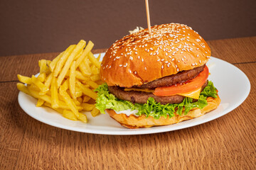 A delicious gourmet burger stacked with fresh vegetables and accompanied by golden crispy fries