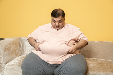 Obesity - Unhappy overweight indian man have problem with big belly fat. Plus size asian guy weight...
