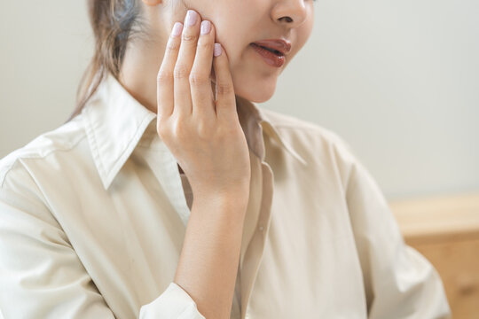 Jaw pain, health care concept. Teeth pain and dentistry asian young woman, girl suffering touching her cheek. Female feeling painful toothache. Unhappy feel bad, diseases in oral, ache nerve and molar