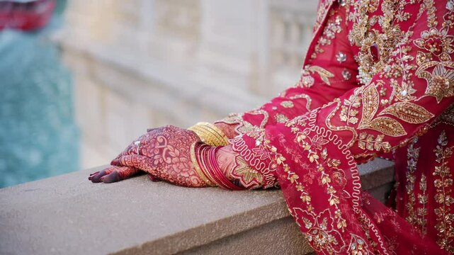 Traditional henna painting on bridal hands. Elements of hindu wedding. Red color is the traditional Indian clothes,