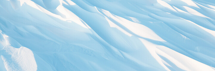 Snow texture. Wind sculpted patterns on snow surface. Wind in the tundra and in the mountains on the surface of the snow sculpts patterns and ridges (sastrugi). Arctic, Polar region. Winter background