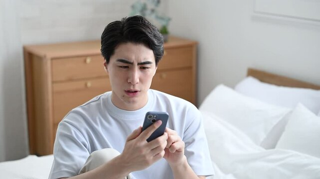 寝起きに不穏なメールやチャットを見てしまう若い男性　仕事困るや株や投資の下落などの落ち込むネガティブイメージの動画