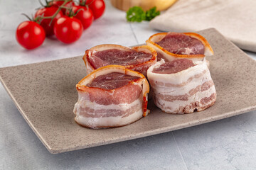 Raw pork tenferloin with bacon