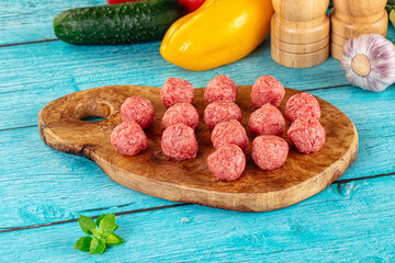 Raw beef meatballs over board