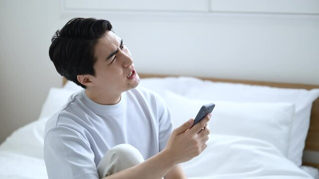 寝起きに不穏なメールやチャットを見てしまう若い男性　仕事困るや株や投資の下落などの落ち込むネガティブイメージの動画