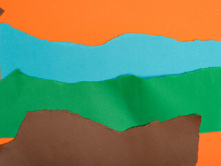 Torn pieces of orange, teal, green, and brown paper layered to create a landscape-like effect