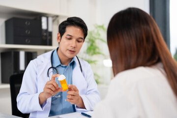 Doctor, pharmacist holding a medicine bottle, gives advice, recommends how to take medicine to ...