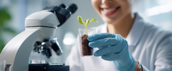 The scientist examining a young plant specimen using a microscope in the laboratory.