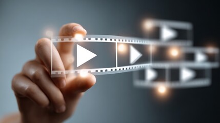 A hand interacts with digital film strip icons, representing multimedia and tech.