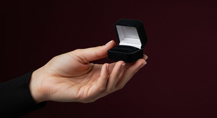 Woman holding an open black velvet engagement ring box