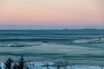 Overlooking the snow-covered beaches of arctic norway, near the town of Bodo, during the golden...