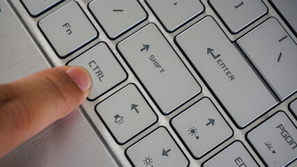 Full frame and close up view of finger pressing control or ctrl button of a laptop keyboard...