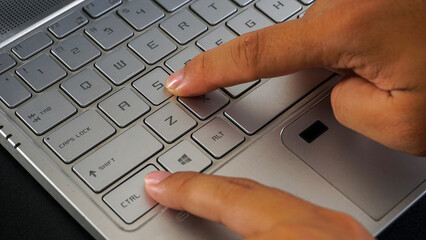 Close up view of finger pressing control and S letter button or ctrl + S on laptop keyboard,...