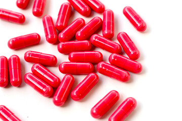 Red astaxanthin supplement capsules on a white background.