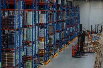 Large warehouse with tall blue racks and forklifts