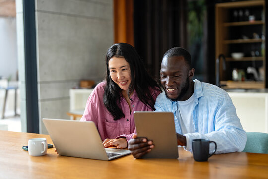 Man and woman working remotely using laptop. Male female freelancers working together. Digital nomad