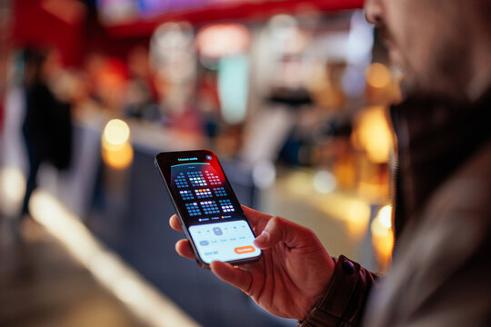Man booking theater seats with app.