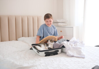 A joyful and playful child happily packing for a fun vacation with adorable cute cats in a suitcase on a cozy bed