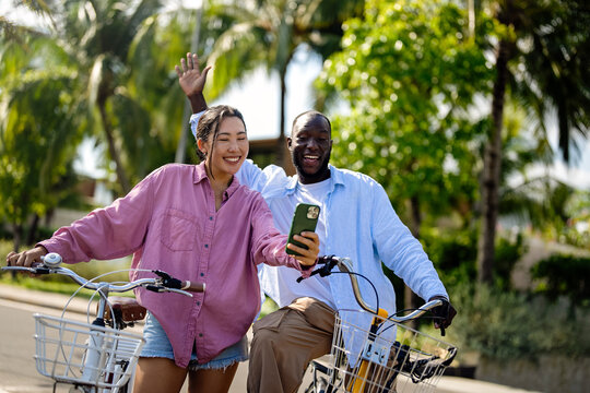 Interracial couple embracing technology, diverse couple enjoying vacation travel relaxation - Powered by Adobe