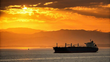 Obraz premium Oil trade international. Oil tanker cargo ship sunset ocean silhouette transport shipping dramatic sky international trade peaceful ,global shipping, energy, crude oil market, energy economy