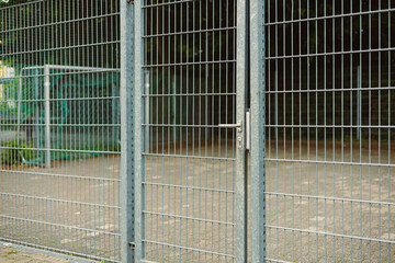 An Industrial Metal Fence Gate, situated in a bustling Urban Setting, serves as a Secure Barrier,...