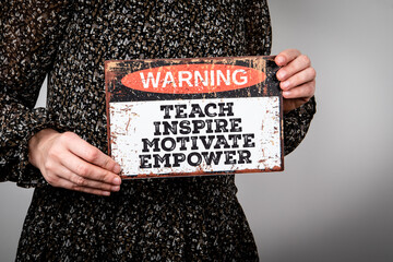 Woman Holding Inspirational Sign with Motivational Message to Teach, Inspire, Motivate, Empower...