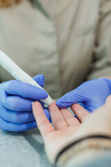 A health practitioner is conducting a blood sugar test with a patient in a clinical setting,...