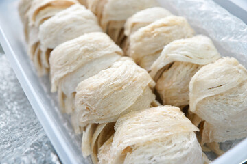 Close-up of premium dried edible bird's nests neatly arranged in a clear plastic box. A luxurious...